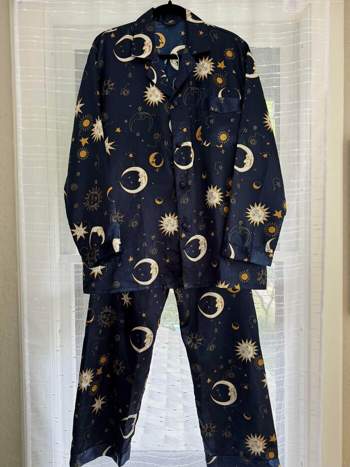 A pair of navy blue pajamas with a moon and sun pattern, a jackpot find at the thrift store.