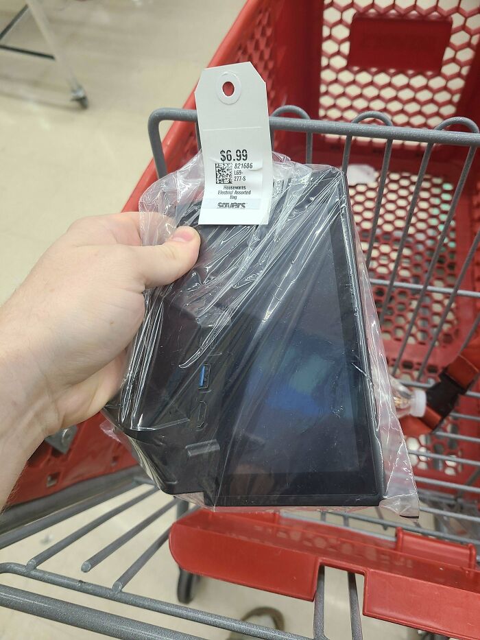 A hand holding a packaged electronic device with a $6.99 price tag, a thrift store jackpot.