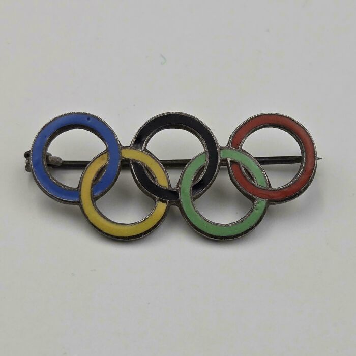 A vintage Olympic rings pin, a rare thrift store jackpot, featuring the iconic interlocking colored rings.