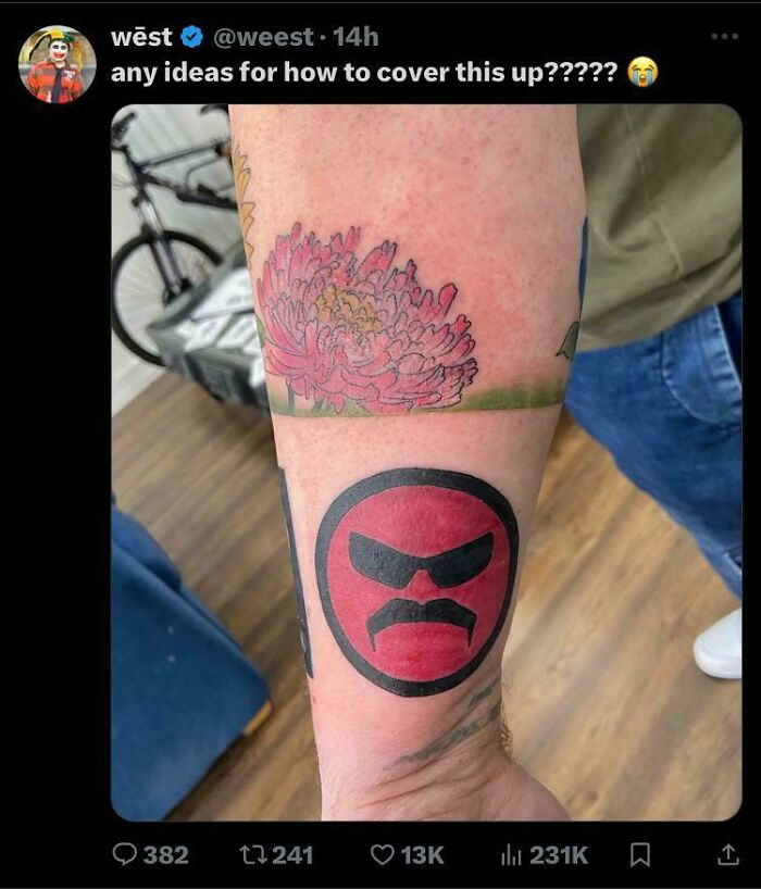 An arm with tattoos, including a pink flower and a red face with a mustache, that aged poorly.
