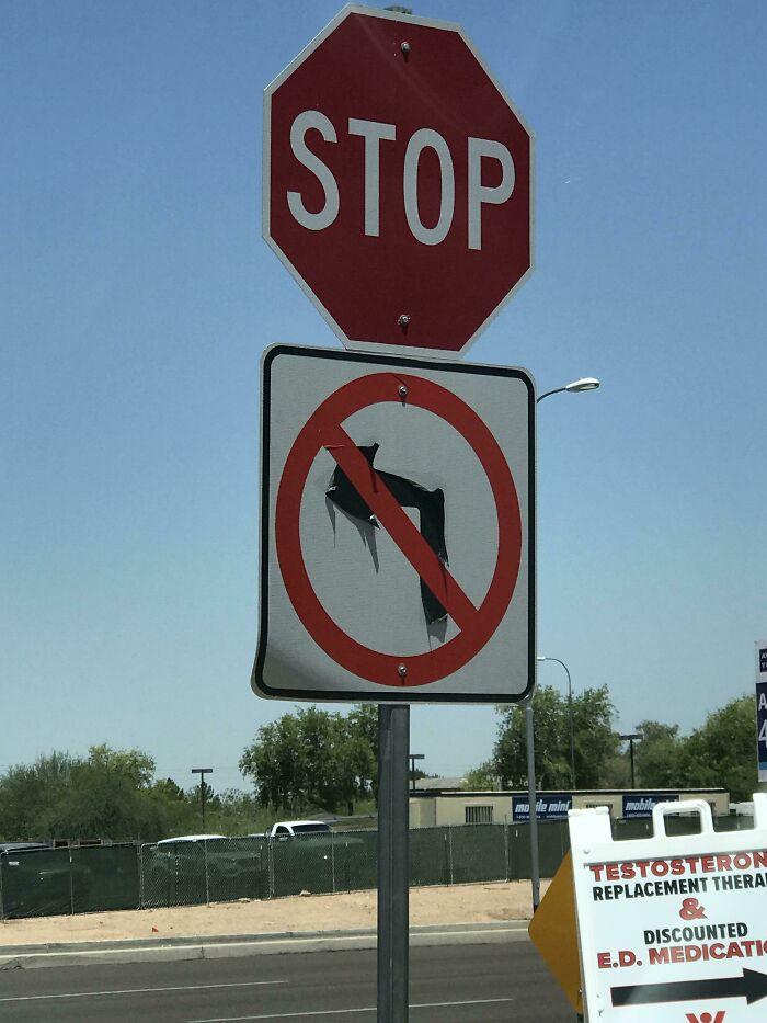 A bent and melted no left turn sign below a stop sign, showing summer melting everything.