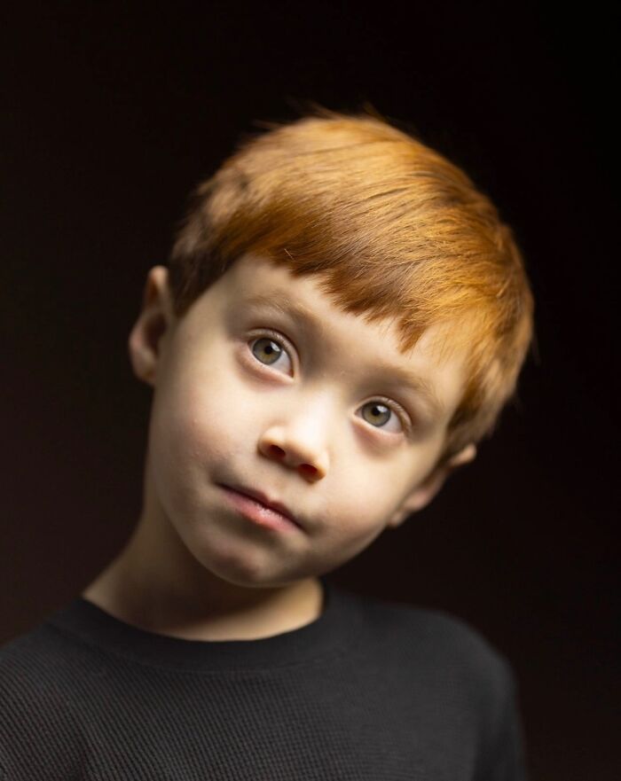 Portrait of a young natural redhead boy with short red hair and bright eyes.