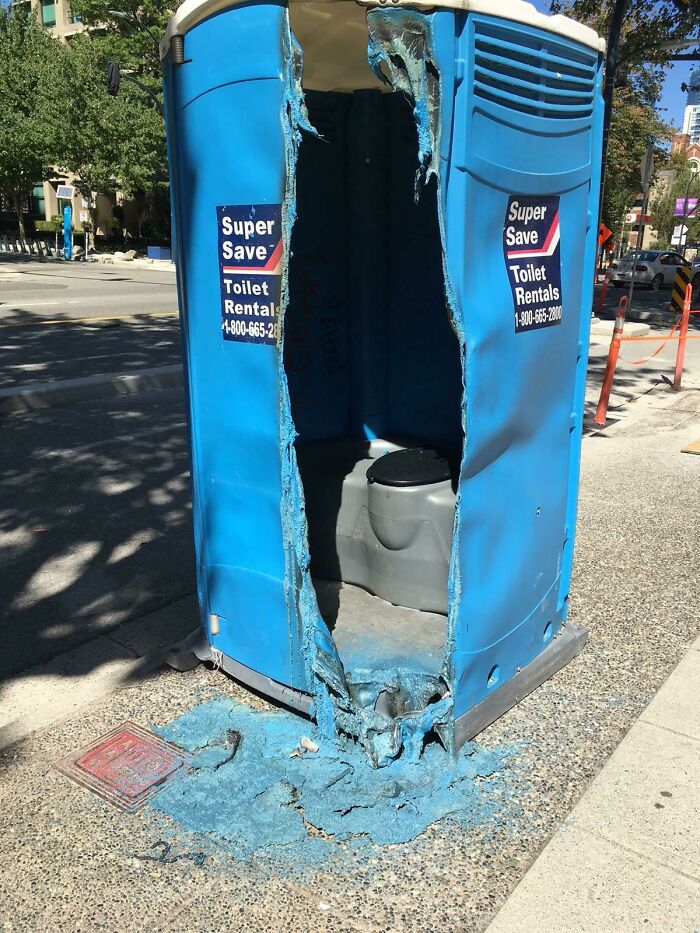 A blue portable toilet completely melted and ruined by the intense summer heat.