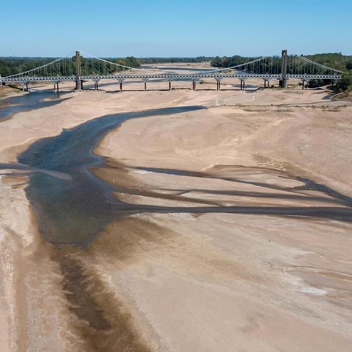 Riverbed nearly dry, revealing extensive summer melting and environmental ruin.