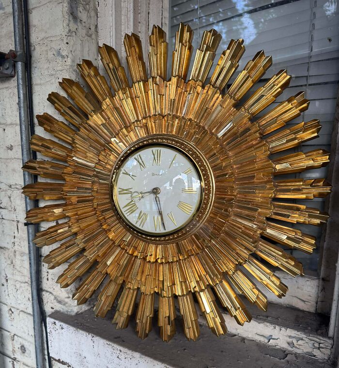 A large ornate golden sunburst clock, a vintage jackpot discovered at the thrift store.