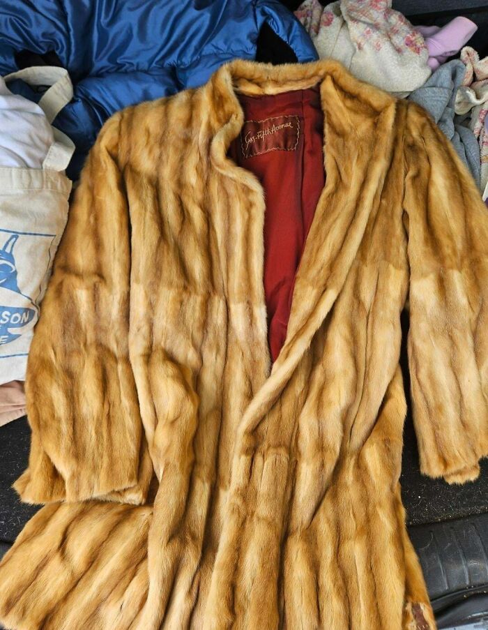 A luxurious long fur coat with a red lining, an incredible fashion jackpot from a thrift store.