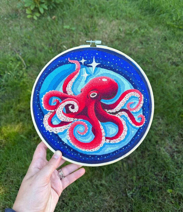 Vibrant embroidery projects of a red octopus under a starry night sky in an embroidery hoop