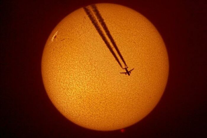 A confusing pic of an airplane silhouetted against the sun, leaving a contrail, creating misleading headlines.
