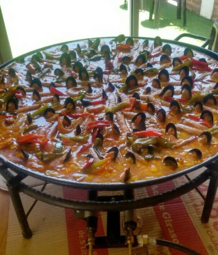 A large pan of paella with mussels that look like tiny people, a prime example of confusing pics.