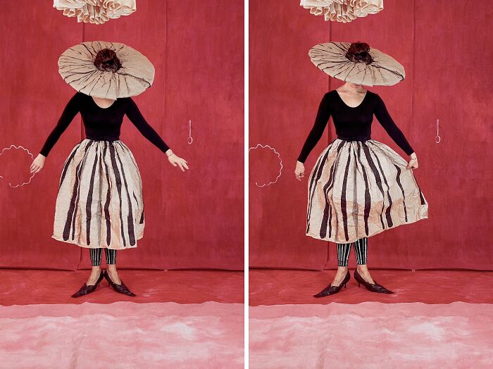 Woman in surreal paper creations: a wide-brimmed hat and striped skirt, showcasing paper fashion and photography.