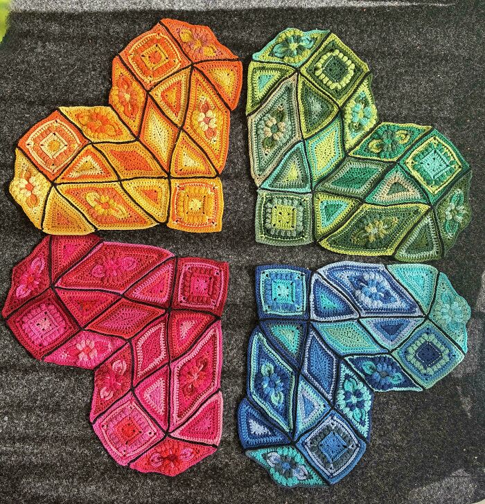 Colorful crochet hearts arranged on dark background