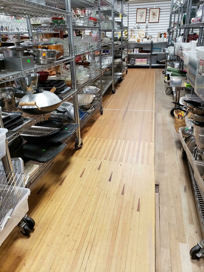 A bowling alley floor repurposed in a building that is pretending to be something it is not.