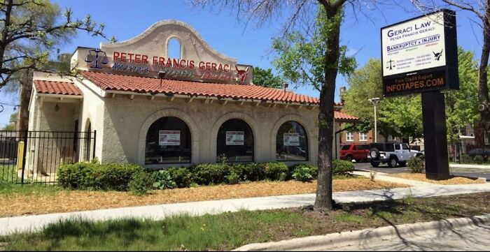A building pretending to be something else, likely an old house, now a law office with a red tiled roof and archways.
