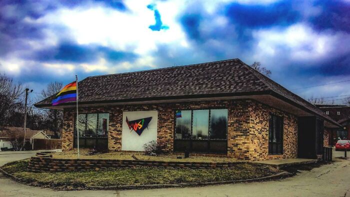 A brick building with a rainbow flag, pretending to be a VOS.