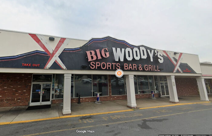 A building pretending to be Big Woody's Sports Bar & Grill with a large sign.