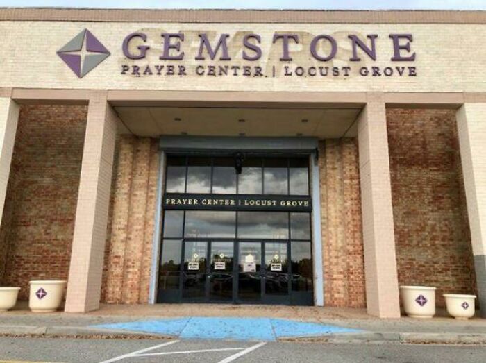 A Gemstone Prayer Center building pretending to be a retail store, with large glass entrance doors.