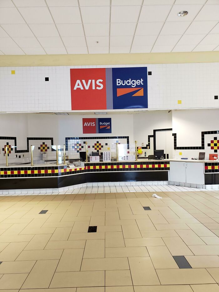 Empty Avis and Budget car rental counter, one of many buildings pretending to be something else.