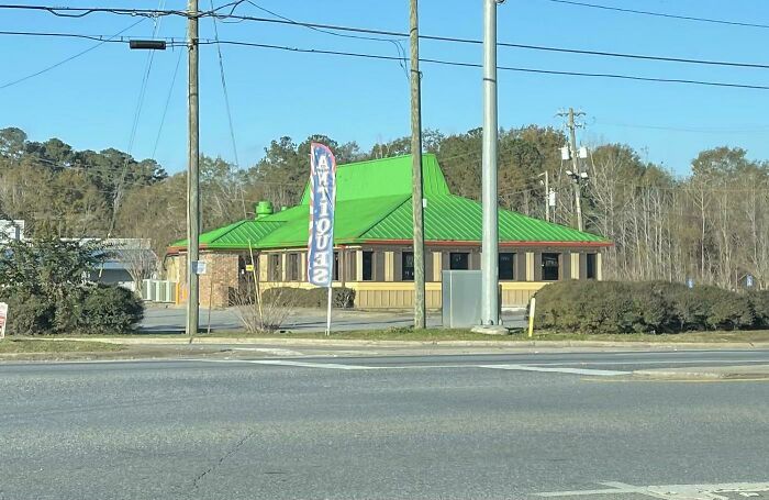 Building with a bright green roof, one of many buildings pretending to be something else.