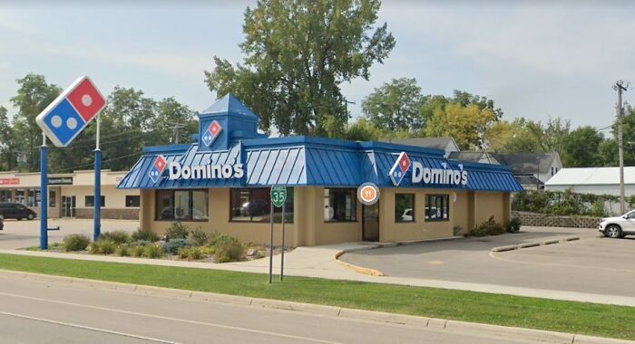 Domino's Pizza, a building pretending to be something it is not, with its distinctive blue roof and logo.