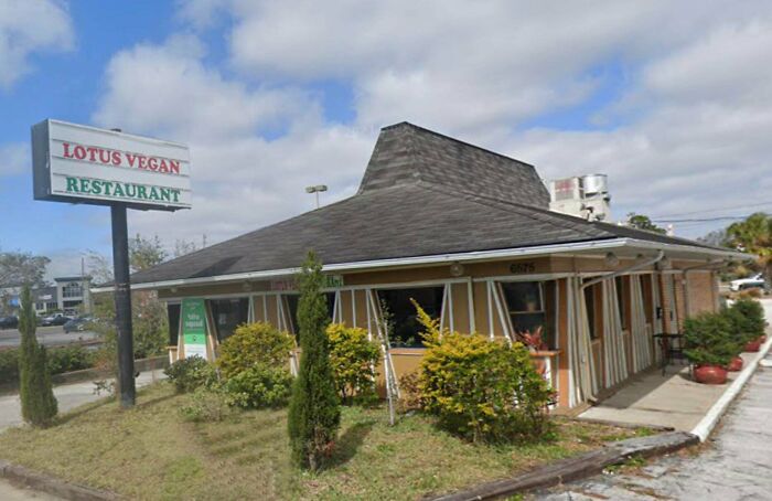 A Lotus Vegan Restaurant in a building pretending to be something else, with a distinct roof shape.