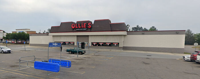An Ollie's Bargain Outlet store in a large parking lot, an example of buildings pretending to be something they're not.