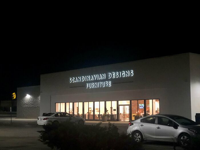 A Scandinavian Designs Furniture store at night, a building that is pretending to be something it's not.