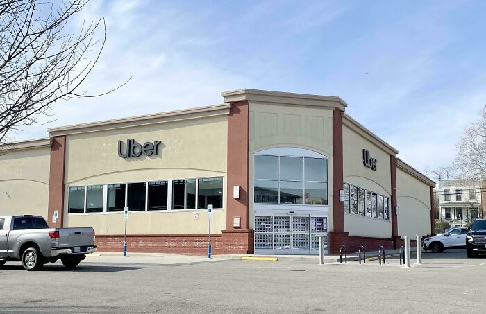 An Uber office in a large retail building with a parking lot, one of many buildings pretending to be something they're not.