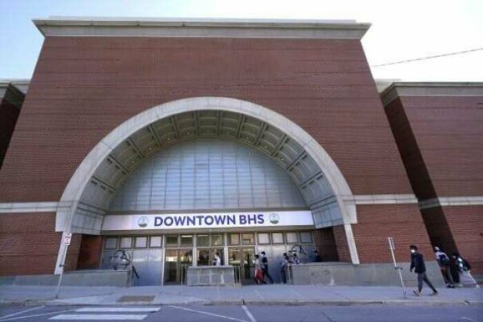 A brick building with an arch entrance and Downtown BHS sign, one of many buildings pretending to be something else.