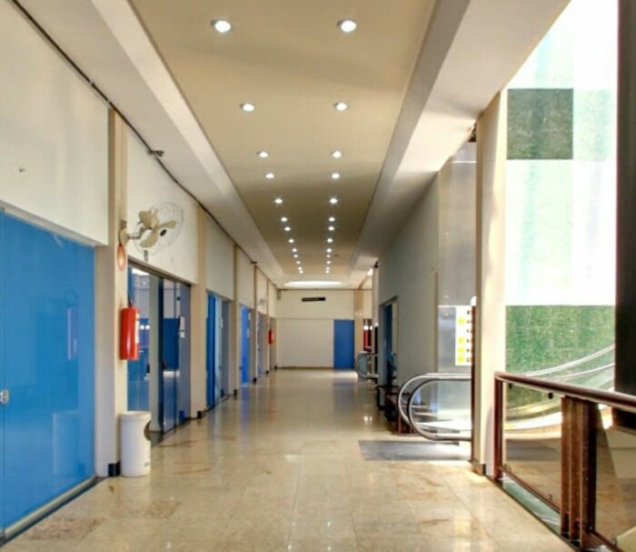 A long, well-lit corridor with blue doors, possibly a building pretending to be something other than a typical hallway.