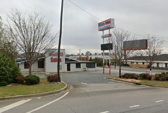 A former Pizza Hut building now used for vehicle sales, one of many buildings pretending to be something they're not.