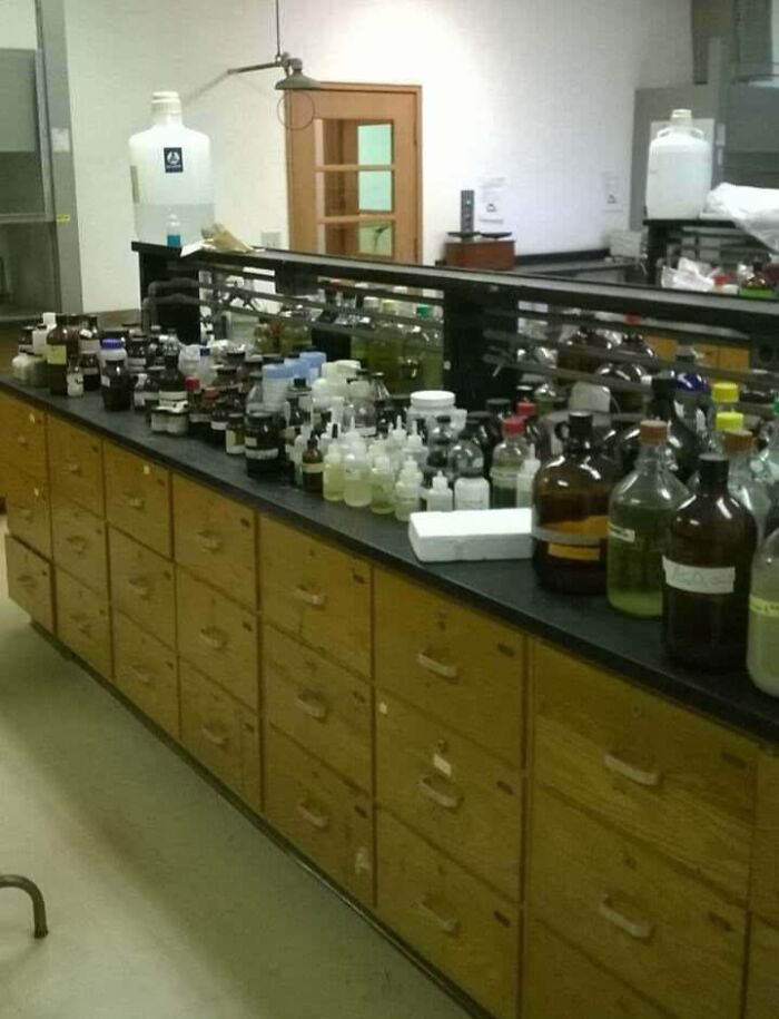 A cluttered laboratory counter with numerous bottles, potentially dangerous things in a lab setting.