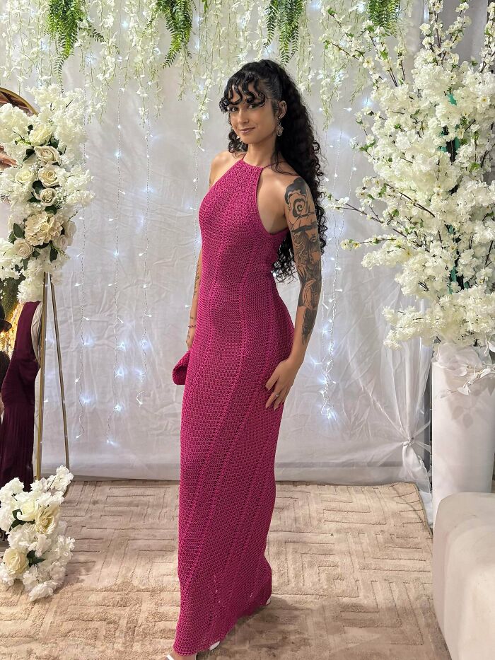 Woman wearing a fitted pink crochet dress posing indoors