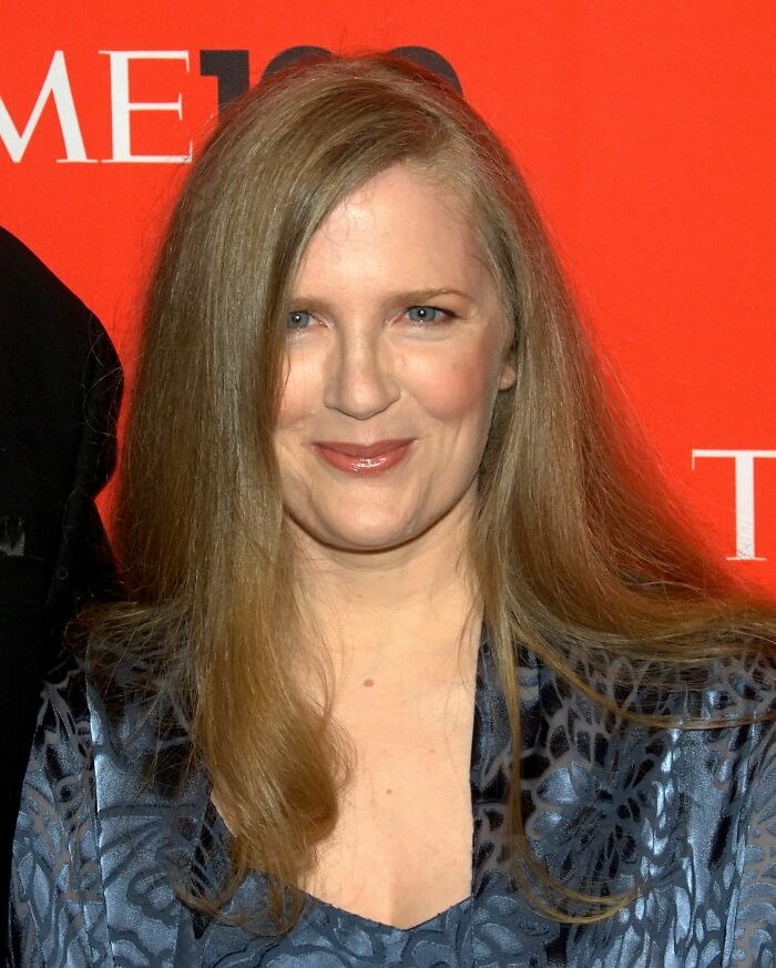 Suzanne Collins smiling, highlighting her career with a red background.