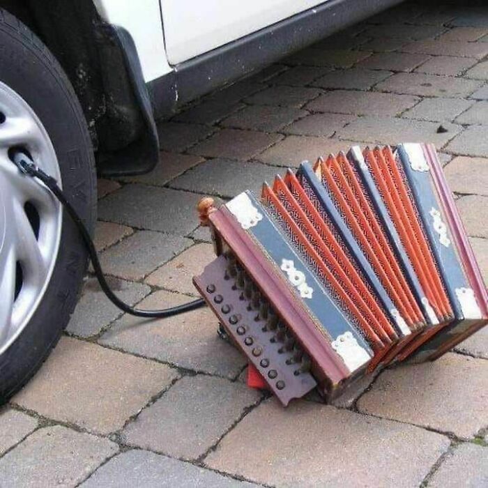 A peculiar image of an accordion used to inflate a car tire, one of many pics that people cannot explain.