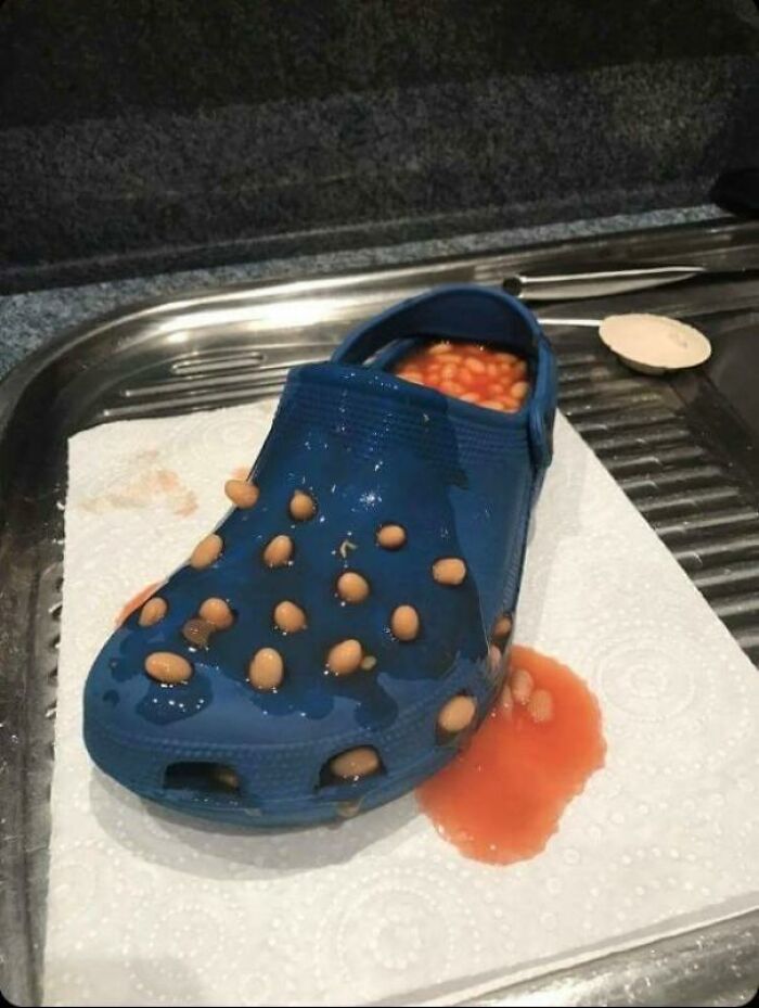 A blue Croc shoe filled with baked beans and spilled sauce, one of the many pics that people cannot explain.