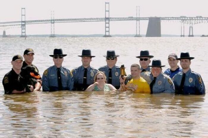 Police officers and civilians in water with a bridge in the background, a pic people cannot explain.