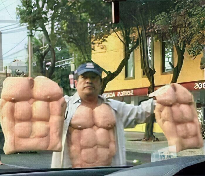 A man wearing a muscle suit and large muscular gloves, an image that people cannot explain or forget.