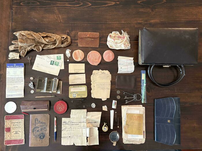 Various pieces of vintage ephemera including documents, keys, and personal items laid out on a table.
