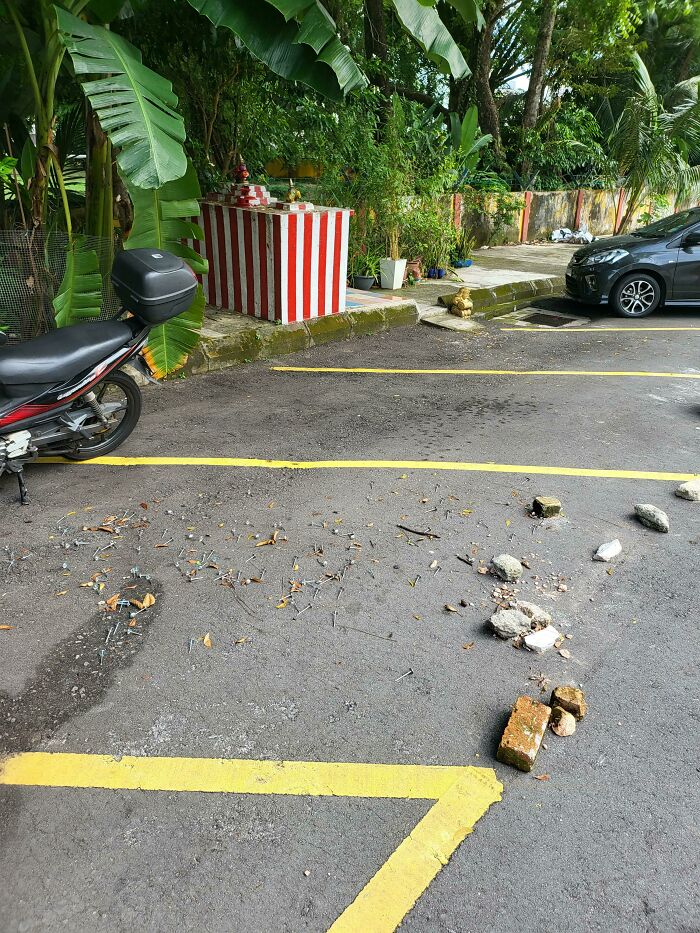 Debris and bricks in a parking spot, indicating a lack of common sense in parking among jerk neighbors.