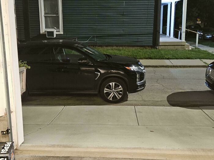 A black car poorly parked, blocking a sidewalk. Neighbors parking badly often lack common sense.