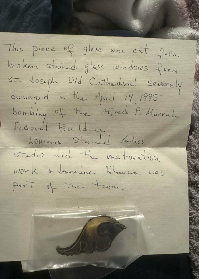 A small piece of stained glass with a handwritten note, a fascinating example of historical ephemera.