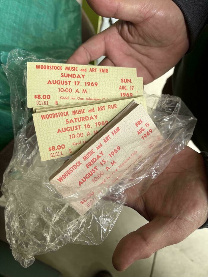 Hands holding Woodstock Music and Art Fair tickets from 1969, an example of ephemera from the past.