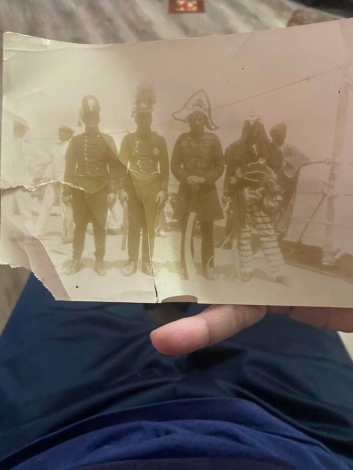 An aged, sepia-toned photograph of four men in historical uniforms, a piece of ephemera from the past.