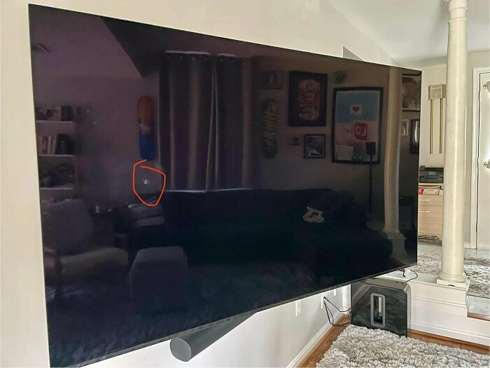 A large TV screen with a small, circled impact mark, illustrating the trials of parents.