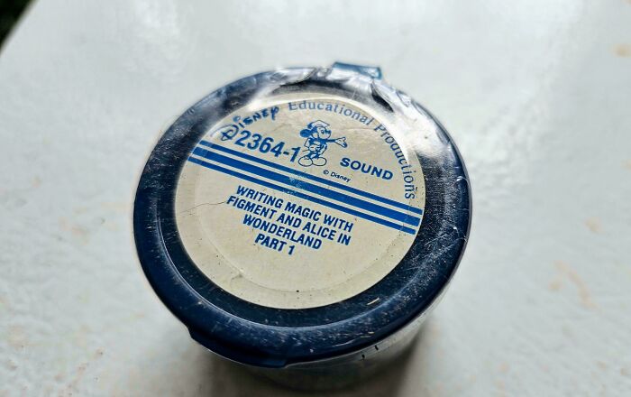 A circular Disney Educational Productions sound reel labeled WRITING MAGIC WITH FIGMENT AND ALICE IN WONDERLAND PART 1, a piece of old ephemera.