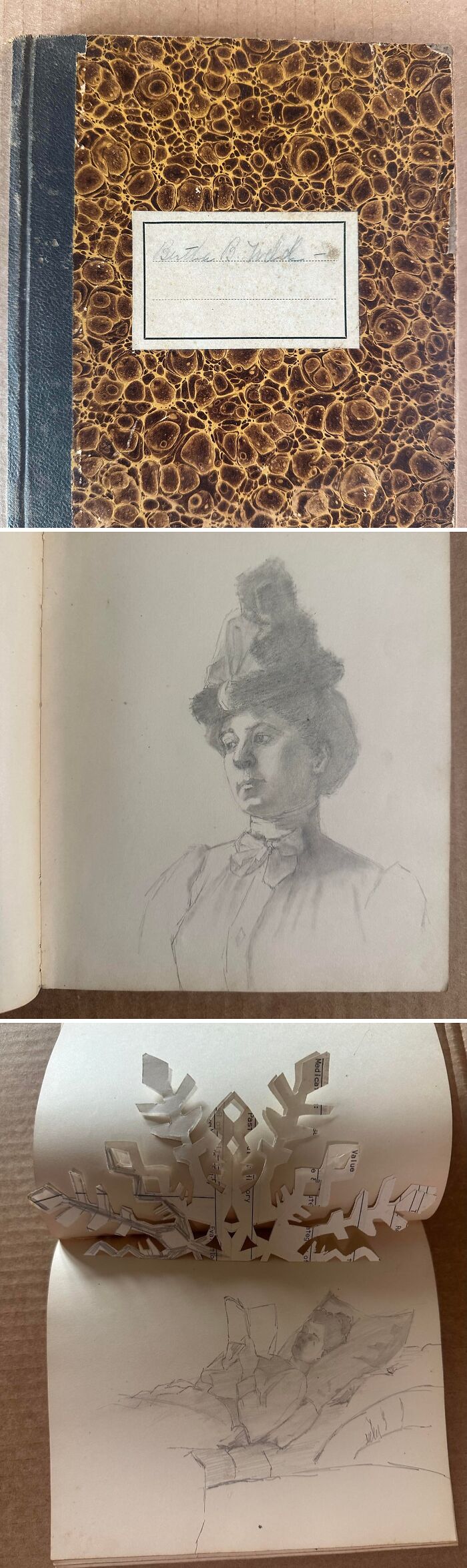 Notebook with marbled cover, a pencil sketch of a woman, and a paper snowflake, examples of ephemera.