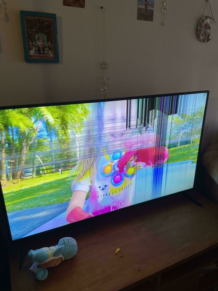 A broken TV screen with vertical lines, displaying a colorful image, a common scenario for parents.
