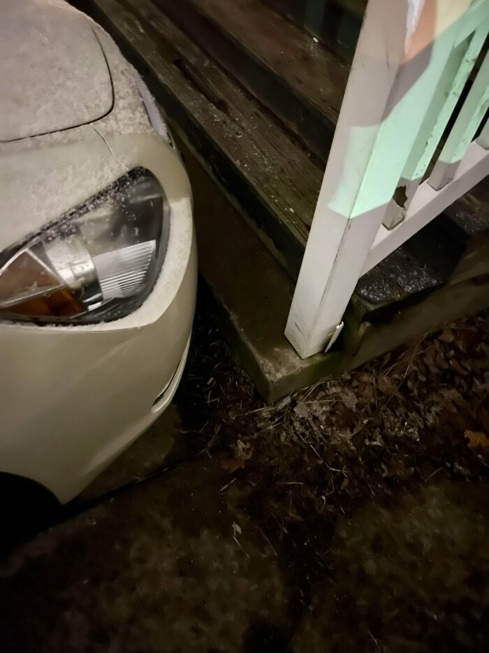 A white car parked extremely close to a snowy porch, highlighting bad parking by jerk neighbors.