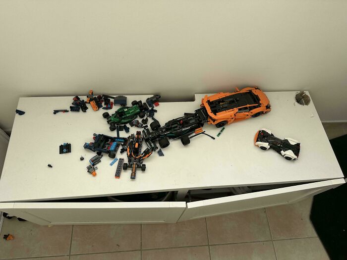 Various toy cars and Lego pieces scattered on a white table reflect parents navigating messy situations.