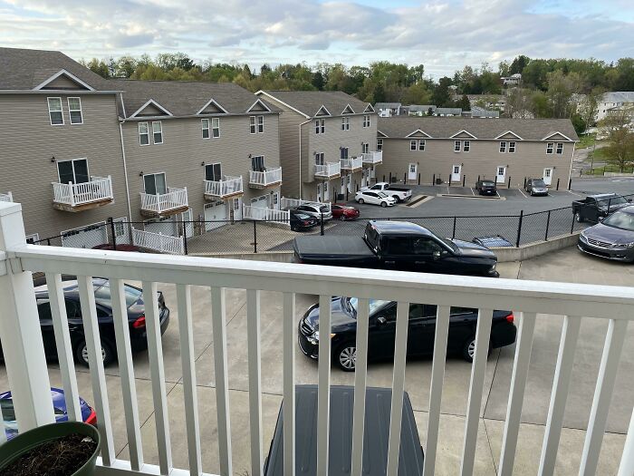An overhead view of a parking lot filled with many cars, showcasing varied parking behaviors of neighbors.
